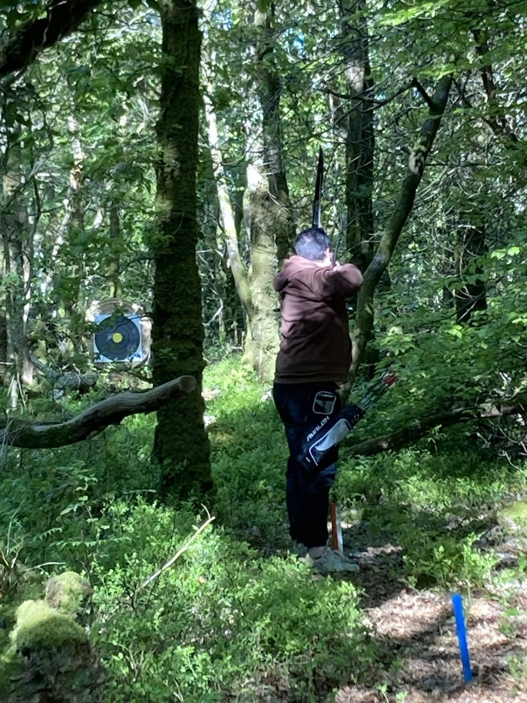 Archer du club visant une cible en sous-bois